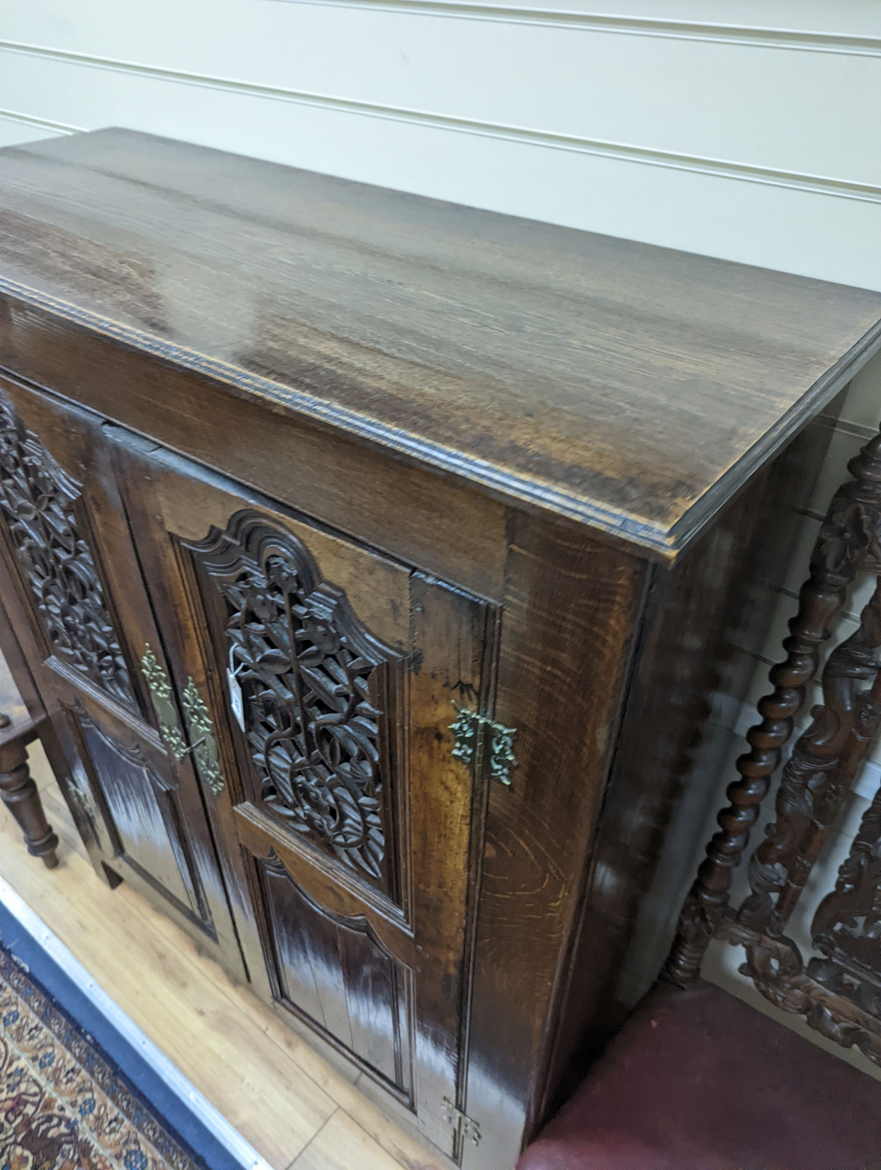 An 18th century and later French carved oak side cabinet. W-112cm, D-46cm, H-136cm.